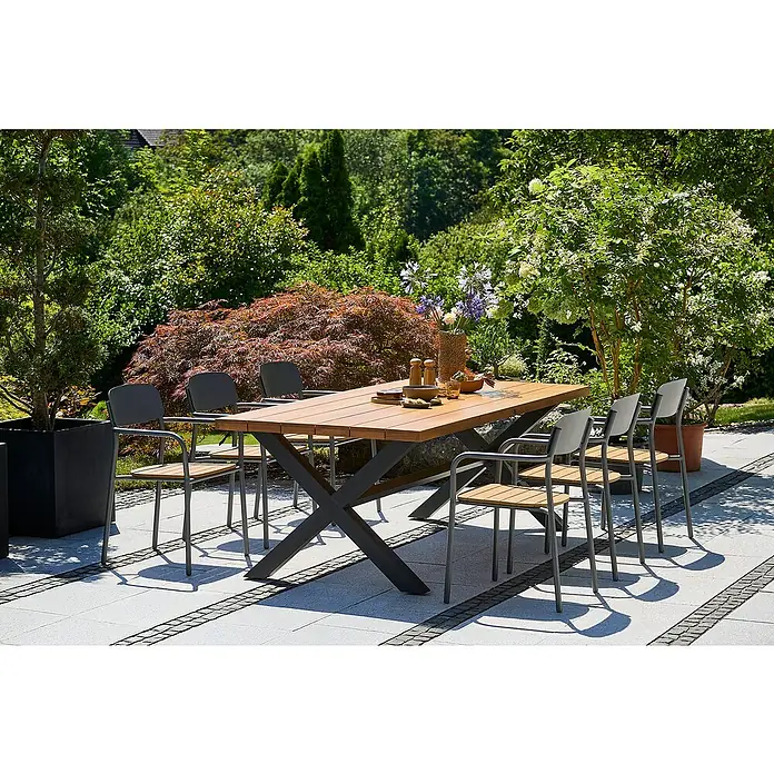 Sunfun Gastro Gartenmöbel-Set - 7 -tlg., Aluminium, Stahl, Eschenholz, Polywood, Anthrazit, Braun, Night-Grey - Ein Gartentisch mit Holzplatte und Metallbeinen steht mit passenden Stühlen auf einer Terrasse, umgeben von üppigem Grün.