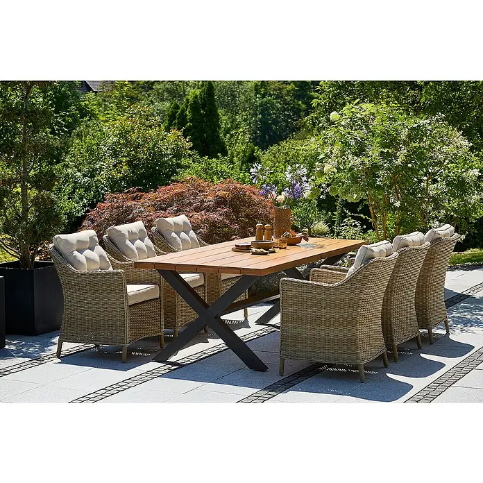 Sunfun Pauline Gartenmöbel-Set II - 7 -tlg., Aluminium, Eschenholz, Polyrattan, Anthrazit, Braun - Dieses Bild zeigt ein Gartenset mit einem Holztisch und Korbstühlen mit Polsterung. Das Set steht auf einer Steinterrasse vor üppigem Grün.