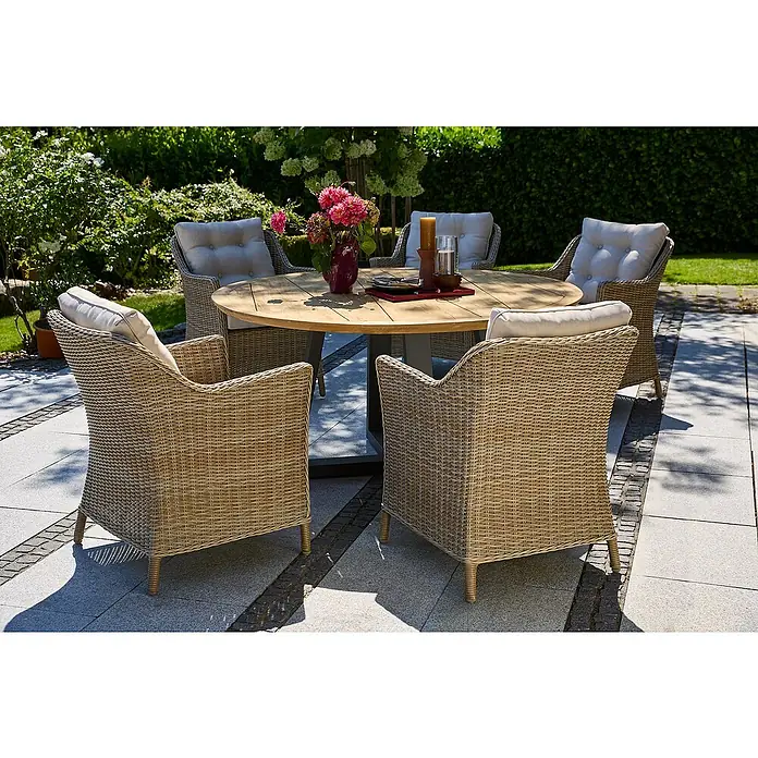 Sunfun Pauline Gartenmöbel-Set II - 7 -tlg., Aluminium, Teak, Akazie, Polyrattan, Anthrazit, Beige - Ein runder Gartentisch aus Holz mit geflochtenen Stühlen und hellen Polstern. Das Arrangement steht auf einer gepflasterten Terrasse im Freien.