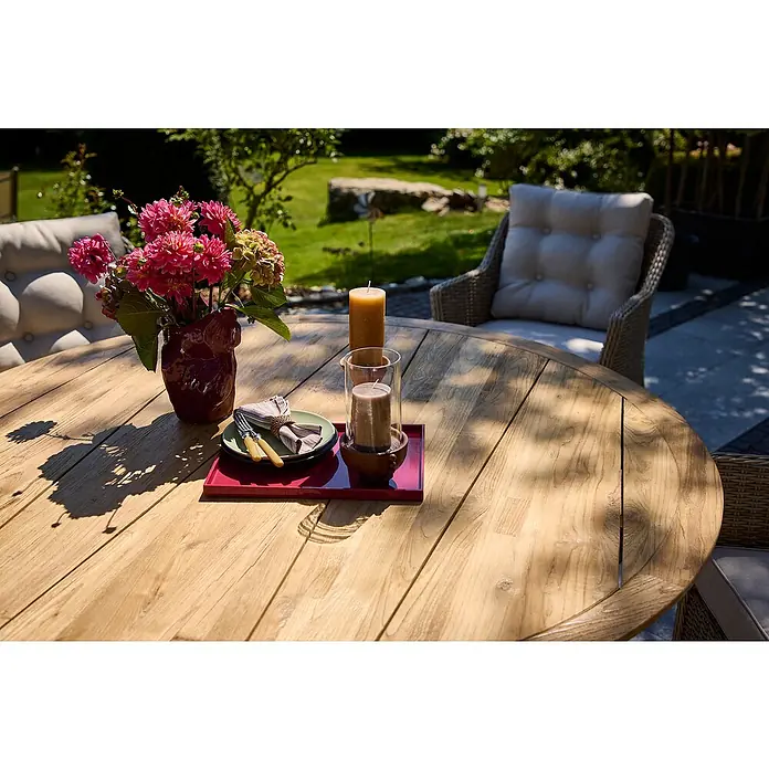 Sunfun Garten-Tischplatte - Durchmesser: 150 cm, Teak, Natur - Eine Nahaufnahme eines runden Holztisches mit Blumen, Kerzen und Geschirr auf einer Terrasse.