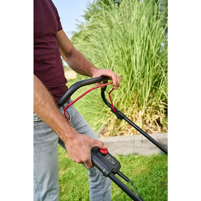 AL-KO 18V/36V Akku-Rasenmäher 43.6 - 18 V - 36 V, 2 Akkus, 5 Ah, Schnittbreite: 43 cm - Eine Person bedient einen Rasenmäher mit roter Starttaste, um den Rasen im Garten zu pflegen.