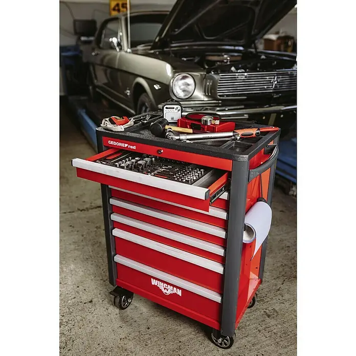 Gedore red Werkstattwagen Mechanic - Ohne Werkzeug, Anzahl Schubladen: 6 Stk. - Werkzeugwagen von GEDOREred mit geöffneter Schublade und Werkzeugen, im Hintergrund ein Oldtimer.