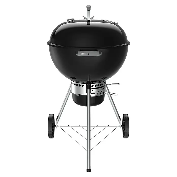 Weber Original Kugelgrill Kettle Premium - Durchmesser Grillfläche: 57 cm, Schwarz - Hier ist ein Weber Holzkohlegrill mit Rollen, ideal für Grillabende. Der Grill hat eine schwarze Kugel und silberne Beine für Stabilität.