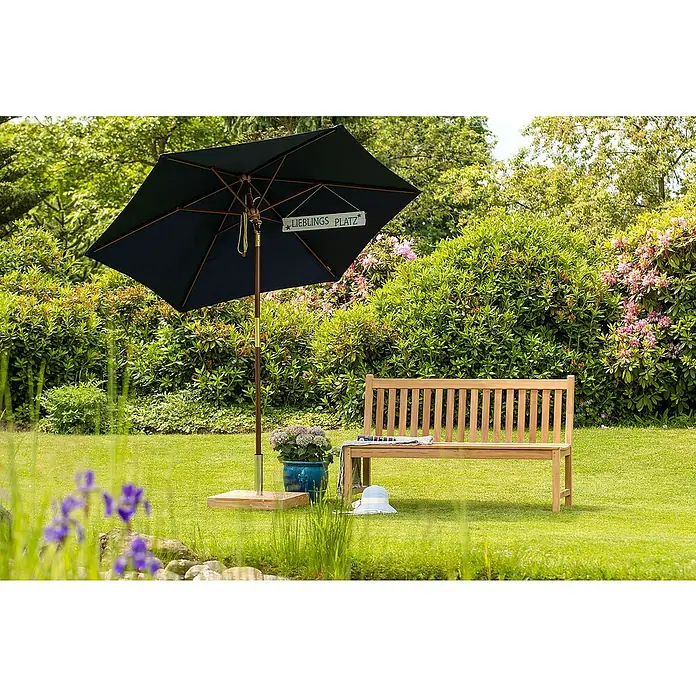 Kai Wiechmann Gartenbank - B x T x H: 150 x 57 x 92 cm, Teak, Naturbelassen - Eine Gartenszene mit einem dunkelblauen Sonnenschirm, einer Holzbank und üppigem Grün, die zum Verweilen einlädt.