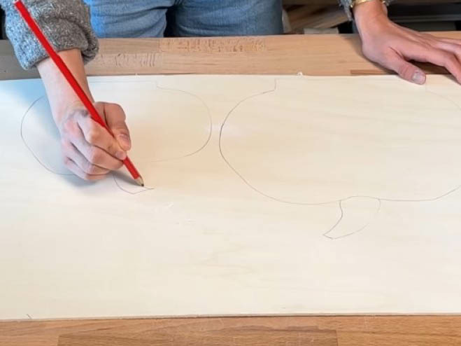 Die Form von Kürbissen werden mit einem Bleistift auf eine Holzplatte aufgezeichnet 