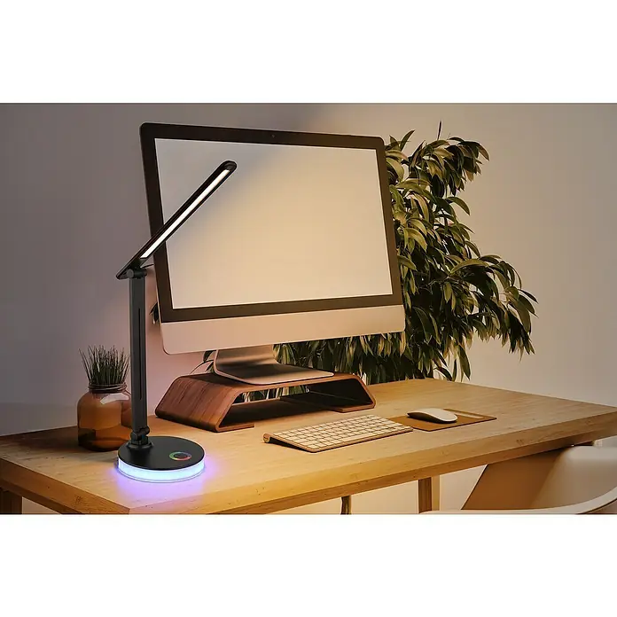 Globo LED-Tischleuchte Geraldo - 5 W, L x B x H: 280 x 150 x 500 mm, Mehrfarbig, Schwarz - Elegante Schreibtischlampe mit RGB-Basis neben einem Computer, die eine moderne Beleuchtungslösung für jeden Arbeitsplatz bietet.