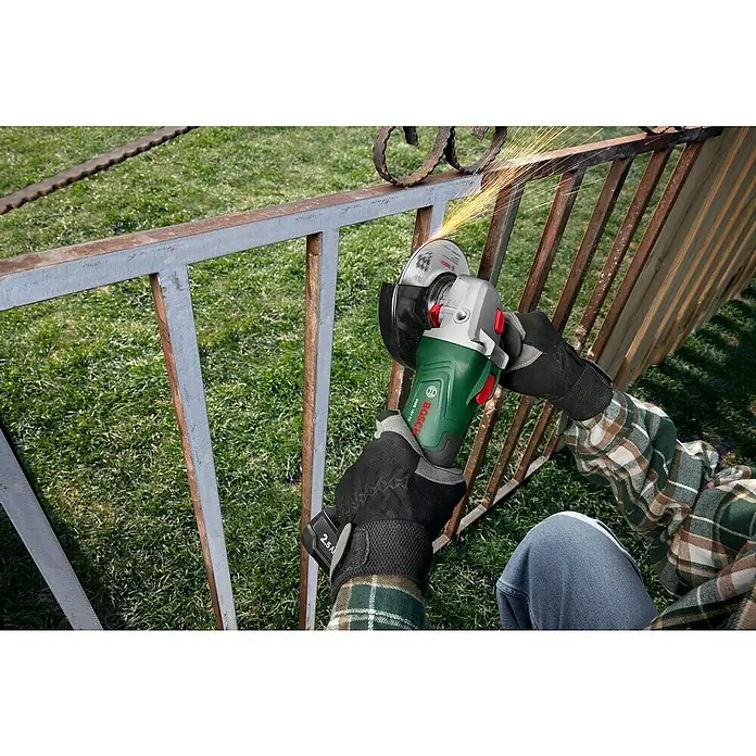 Bosch Power for All 18V Akku-Winkelschleifer PWS 18V-70 - 18 V, Ohne Akku, Durchmesser Scheibe: 125 mm - Ein Akku-Winkelschleifer von Bosch im Einsatz, der an einem Metallgeländer schleift und dabei Funken erzeugt.