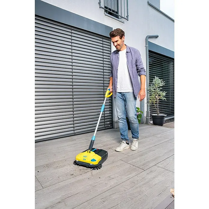 Gloria Power for All 18V Akku-Handkehrmaschine EasySweep 18V - 18 V, Ohne Akku, Arbeitsbreite: 40 cm, 4,5 l - Mann benutzt einen gelben Kärcher Kehrer zum Reinigen einer Terrasse. Das Gerät ist kompakt und benutzerfreundlich.