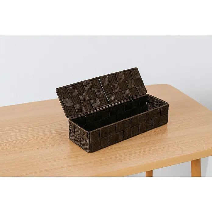 Versa Cesta para el baño con tapa - L x An x Al: 26 x 8 x 6 cm, Chocolate - Una cesta marrón tejida con tapa abierta sobre una mesa de madera. Solución de almacenamiento práctica.