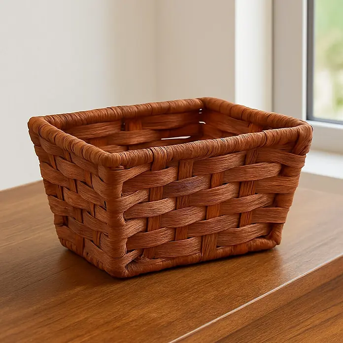 Versa Cesta para baño alta con asas - L x An x Al: 16 x 14 x 9 cm, Fibras plásticas, Marrón - Primer plano de una cesta de almacenamiento cuadrada tejida sobre una superficie de madera, perfecta para la organización del hogar.