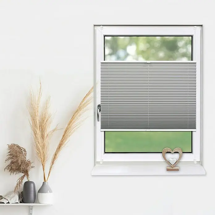 Deco-Raum Plissee ohne Bohren Basic - B x H: 70 x 210 cm, Grau - Fenster mit grauen Plissees, die für Privatsphäre und Lichtsteuerung sorgen, ergänzt durch dekorative Elemente auf der Fensterbank.