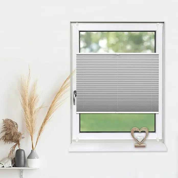Deco-Raum Plissee ohne Bohren Basic - B x H: 70 x 210 cm, Silber - Graue, verspannte Plissees sind an einem Fenster befestigt und sorgen für Privatsphäre und Lichtschutz. Die Fensterbank ist mit Dekorationen versehen.