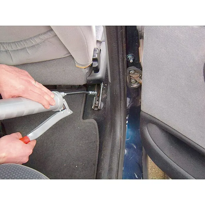 3 en 1 Bomba manual - Apto para: Cartuchos de grasa convencionales - Se está utilizando una pistola de engrase para lubricar un asiento de automóvil, lo que está destinado a garantizar que el asiento se mueva suavemente.