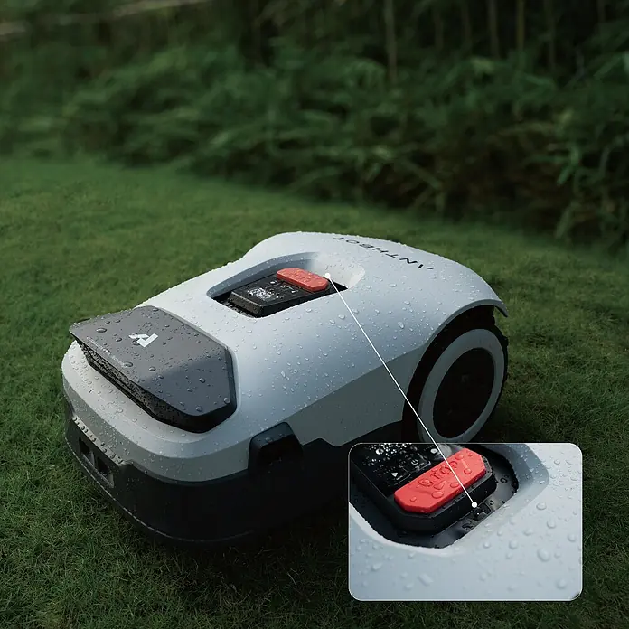 Anthbot Mähroboter Genie 3000 - 3.600 m², Schnittbreite: 20 cm, Satellitengestützte Navigation, RTK - Nahaufnahme eines Antroboter-Rasenmähers im Garten, der für effiziente Rasenpflege sorgt. Wasserdichte Bauweise für den Einsatz bei jedem Wetter.