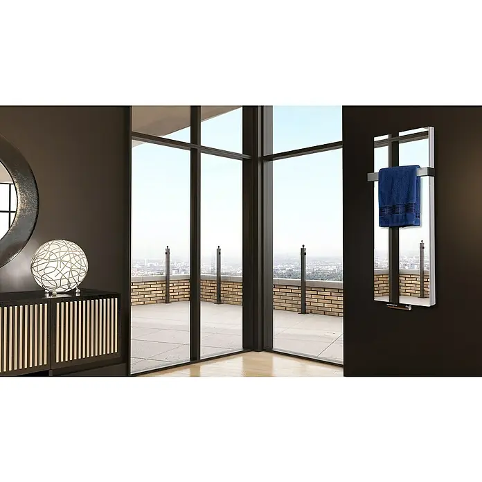 Badheizkörper Mirror - B x H: 470 x 1.200 mm, Nennleistung: 1.458 W, 1 x Halter 50mm, Spiegel - Ein moderner Badezimmerheizkörper mit einem blauen Handtuch hängt an der Wand, ergänzt durch eine stilvolle Einrichtung.