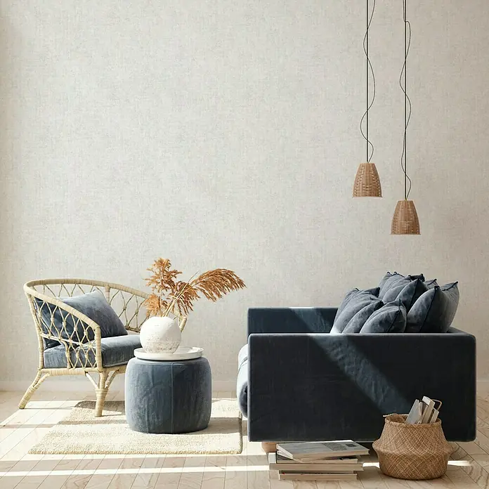 A.S. Création New Walls Vliestapete I - Hellgrau, Uni, 10,05 x 0,53 m - Elegante Wohnzimmergestaltung mit einem bequemen Sessel, einem stilvollen Sofa und dekorativen Lampen, die eine gemütliche Atmosphäre schaffen.