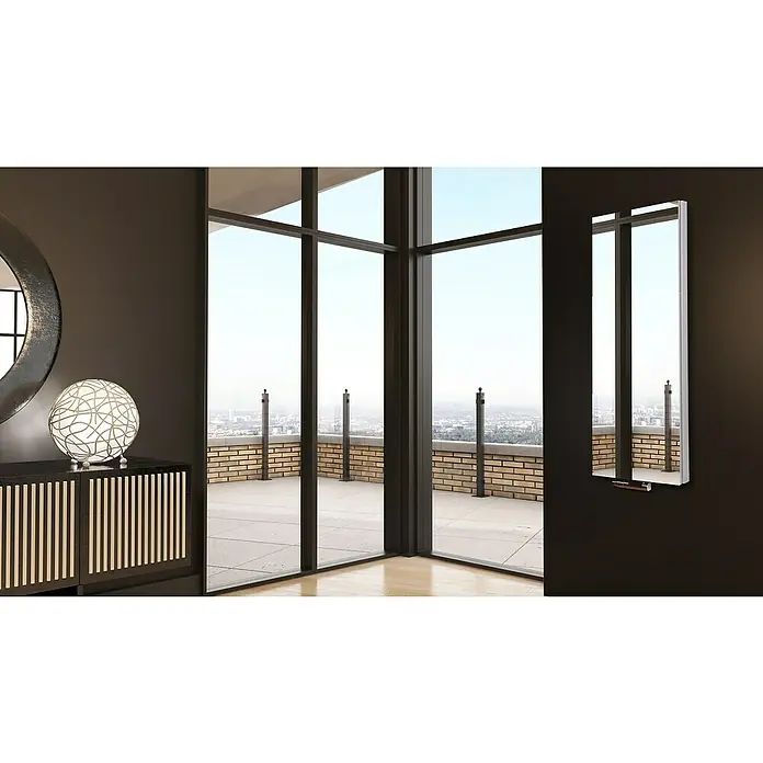 Badheizkörper Mirror - B x H: 470 x 1.200 mm, Nennleistung: 1.458 W, Ohne Handtuchhalter, Spiegel - Moderne Wandleuchte mit schlankem Design neben einer Fensterfront mit Stadtblick. Das Licht sorgt für eine angenehme Atmosphäre.