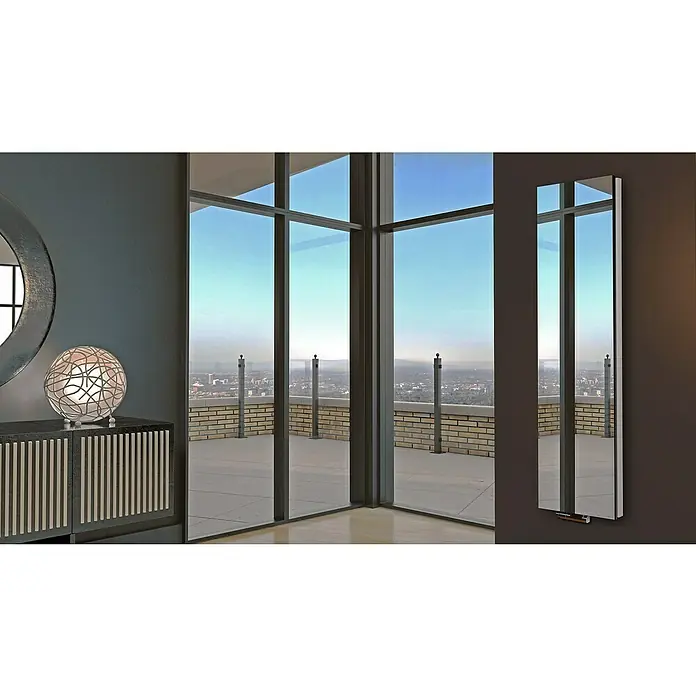 Badheizkörper Mirror - B x H: 470 x 1.800 mm, Nennleistung: 1.964 W, Ohne Handtuchhalter, Spiegel - Spiegelheizkörper vor einer Fensterfront mit Stadtblick.