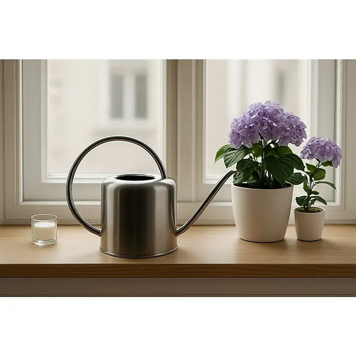 Gießkanne - Edelstahl, 1 l, Silber - Stillleben mit einer eleganten silbernen Gießkanne, lila Hortensien und einem Glas Milch auf einem hellen Holzfensterbrett.