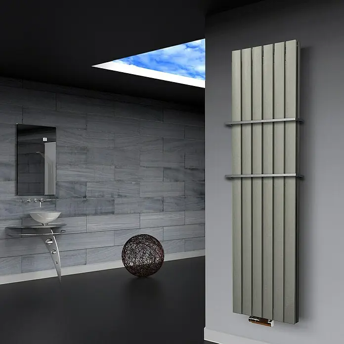 Badheizkörper Peking - B x H: 470 x 1.800 mm, Nennleistung: 1.964 W, Edelstahl, 2 x Halter 15mm - Ein moderner Badheizkörper in Grau hängt an der Wand, ergänzt durch ein stilvolles Waschbecken und eine dekorative Kugel.