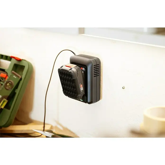 Bosch Power for All 18V Akku & Ladegerät - 2 Akkus, 2,5 Ah - Akkuladegerät mit Akku an einer weißen Wand, daneben eine Werkzeugkiste. Der Akku ist schwarz und rot und das Ladegerät hat ein schlankes Design.