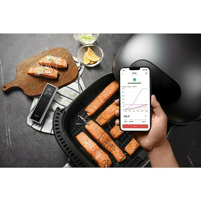 Typhur Grill-Thermometer Sync One - 2 -tlg., Kabellos; Verbindung via Bluetooth oder Wi-Fi - Ein Bild von Typhur-Produkten, darunter ein Thermometer und eine App, die die Temperatur von Lachs beim Kochen überwacht.