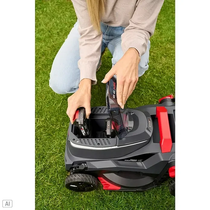 AL-KO 18V/36V Akku-Rasenmäher 34.6 - 18 V - 36 V, 2 Akkus, 2,5 Ah, Schnittbreite: 34 cm - Eine Frau setzt einen Akku in einen grauen Rasenmäher mit roten Akzenten.