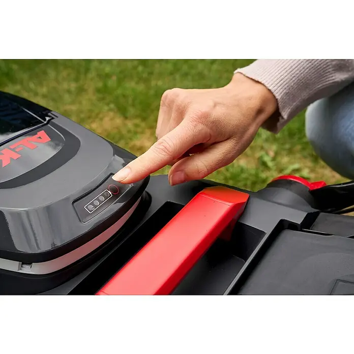 AL-KO 18V/36V Akku-Rasenmäher 34.6 - 18 V - 36 V, 2 Akkus, 2,5 Ah, Schnittbreite: 34 cm - Nahaufnahme eines AL-KO Rasenmähers mit einer Hand, die den Batteriestatus überprüft.