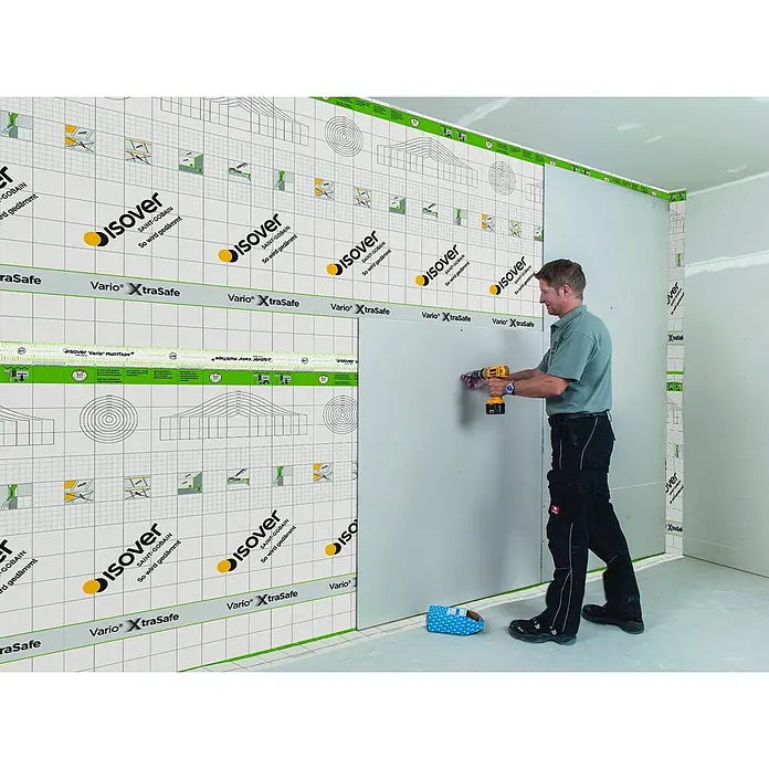 Isover Dampfbremsfolie XtraSafe - L x B: 40 x 1,5 m, 60 m² - Mann montiert eine Isover Vario XtraSafe Dampfbremsfolie mit einem Akkuschrauber an einer Wand.