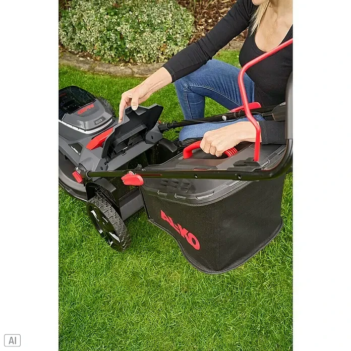 AL-KO 18V/36V Akku-Rasenmäher 38.6 - 18 V - 36 V, 2 Akkus, 4 Ah, Schnittbreite: 38 cm - Eine Frau bereitet einen AL-KO Rasenmäher mit Fangkorb auf einem grünen Rasen für die Gartenarbeit vor.