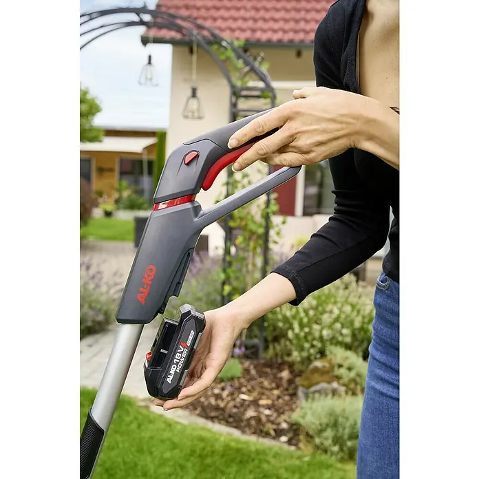 AL-KO 18V/36V Akku-Rasenmäher 22.6 - 18 V - 36 V, 1 Akku, 2,5 Ah, Schnittbreite: 22 cm - Eine Frau setzt einen AL-KO 18V POWER Akku in einen AL-KO Rasentrimmer ein.