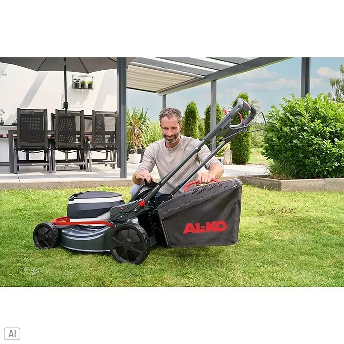 AL-KO 18V/36V Akku-Rasenmäher 51.6 - 18 V - 36 V, 2 Akkus, 8 Ah, Schnittbreite: 51 cm - Ein Mann montiert einen AL-KO Rasenmäher mit Fangkorb in seinem Garten, während er sich auf das Rasenmähen vorbereitet.