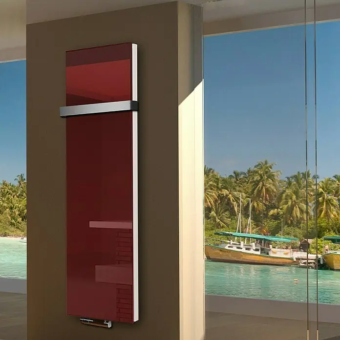 Badheizkörper Montevideo - B x H: 470 x 1.800 mm, Nennleistung: 1.964 W, Rot, 1 x Halter 50mm - Ein moderner, roter Handtuchwärmer hängt an einer Wand vor einem Fenster mit Meerblick. Das Heizgerät besticht durch sein elegantes Design.