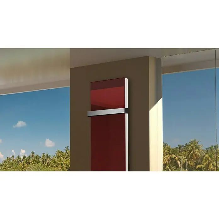 Badheizkörper Montevideo - B x H: 470 x 1.800 mm, Nennleistung: 1.964 W, Rot, 1 x Halter 50mm - Eine rote Glasheizung ist an einer braunen Wand befestigt, mit einem Handtuchhalter. Im Hintergrund sind Fenster mit Palmen und blauem Himmel.