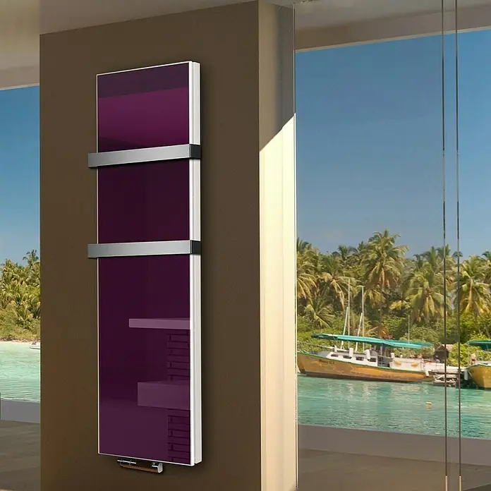 Badheizkörper Montevideo - B x H: 470 x 1.800 mm, Nennleistung: 1.964 W, Violett, 2 x Halter 50mm - Nahaufnahme eines vertikalen, auberginefarbenen Heizkörpers mit Handtuchhaltern an einer Wand mit Blick auf den Ozean.