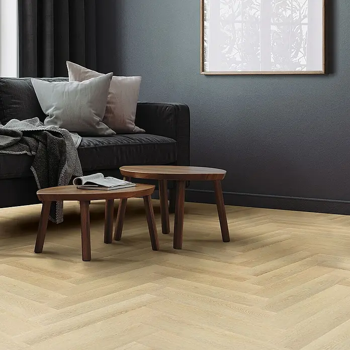 ML-Design Vinylboden 3 x Paket Vinylboden mit 60 Diele = 4,6848 m² - Braun, Landhausdiele, 61 cm x 12,8 cm x 4,2 mm - Ein elegantes Interieur mit hellen Fischgrätparkettböden, einem dunklen Sofa und passenden Beistelltischen, die ein stilvolles Ambiente schaffen.