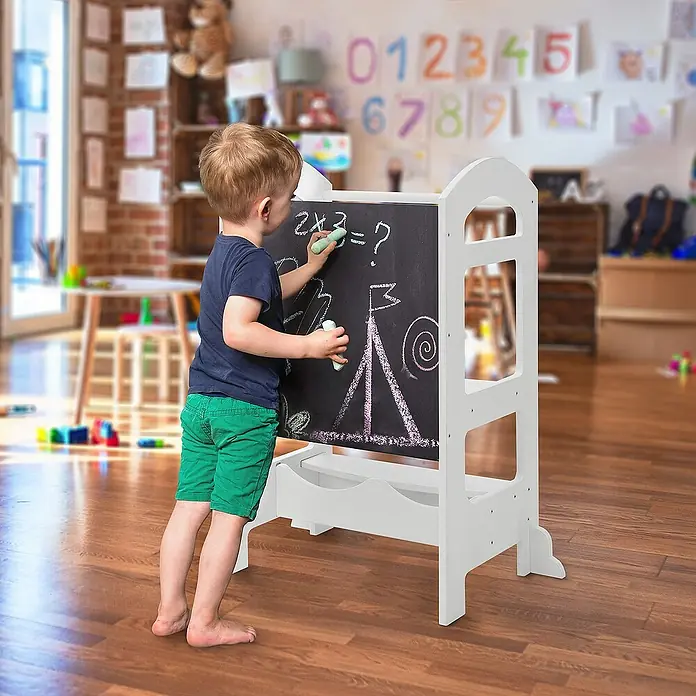 ECD Germany Kinderspielturm Küchenhelfer Weiß mit Tafel und 2 Stufen 70x40x90cm - L x B x H: 70 x 40 x 90 cm, Weiß - Kind benutzt eine weiße Staffelei mit Tafel, auf der Kreidezeichnungen zu sehen sind.