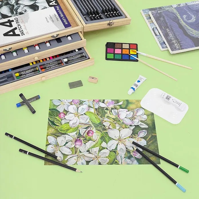 ECD Germany Zeichenstift-Set - Braun - Nahaufnahme eines Malsets mit Skizzenblock, Farben, Pinseln und Stiften auf einem grünen Tisch.