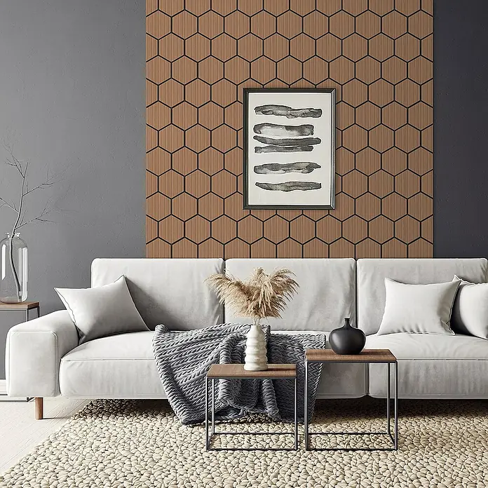 ML-Design Akustikpaneel 2er Set für 1m², Hexagon Wandplatten zur Schalldämmung - Teak, L x B x S: 2,1 cm x 66,6 cm x 2,1 mm, 2 Stk., 1 m² - Wohnzimmer mit weißem Sofa, Teppich und Holzwand mit sechseckigem Muster, die dem Raum Wärme und Textur verleiht.