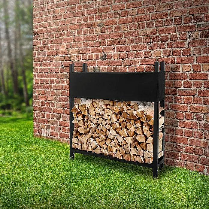 ML-Design Kaminholzregal Brennholzregal wetterfest zum Lagern mit Schutzhülle, Stahl -  - Holzregal aus schwarzem Metall gefüllt mit Holzscheiten, steht an einer roten Backsteinmauer auf grünem Gras.
