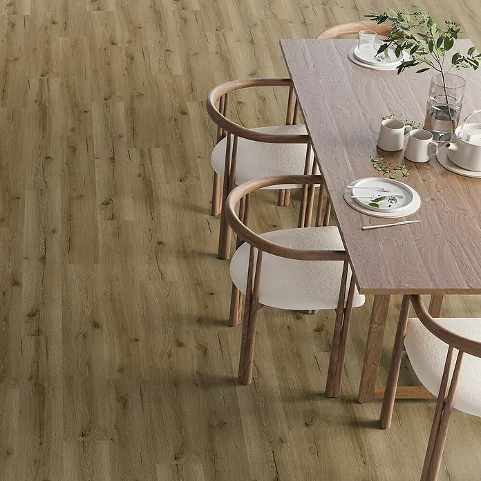 Vinylboden SPC - Eiche Tobacco, Landhausdiele, 1.220 x 182 x 3,5 mm - Detailaufnahme eines Holzfußbodens, der einen Esstisch und Stühle in einem Esszimmer ergänzt. Der Bodenbelag zeichnet sich durch eine warme Farbgebung aus.