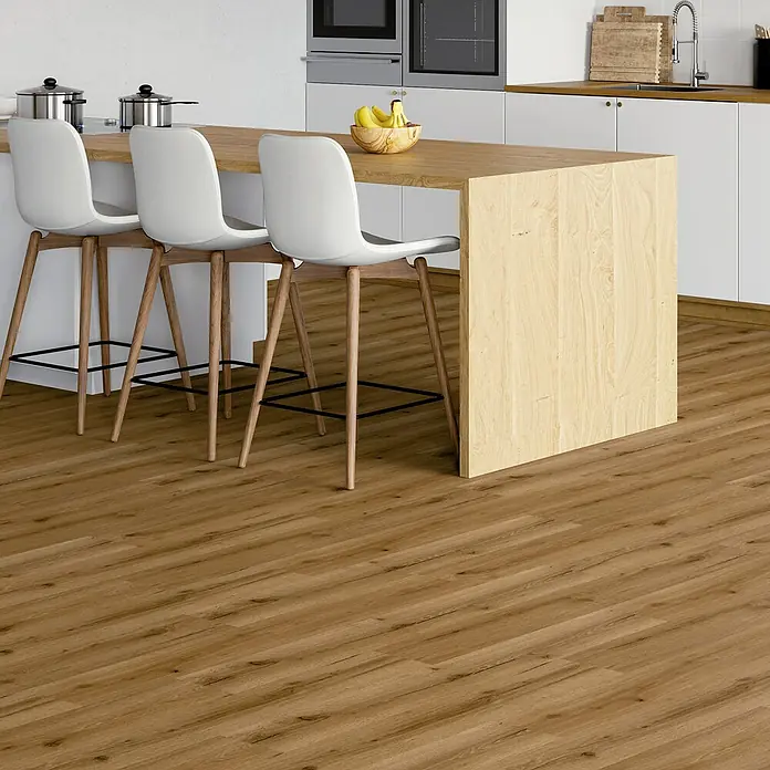 Vinylboden SPC - Eiche Tobacco, Landhausdiele, 1.220 x 182 x 3,5 mm - Küchenaufnahme mit Fokus auf dem Bodenbelag in Holzoptik und den weißen Barhockern an der Kücheninsel.