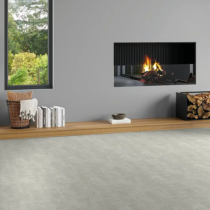 b!design Vinylboden SPC - Hellas, Fliese, 609,6 x 304,8 x 3,8 mm - Einladendes Wohnzimmer mit modernem Kamin, Fenster zum Garten, Holzboden und Bücherregal mit dekorativen Elementen.