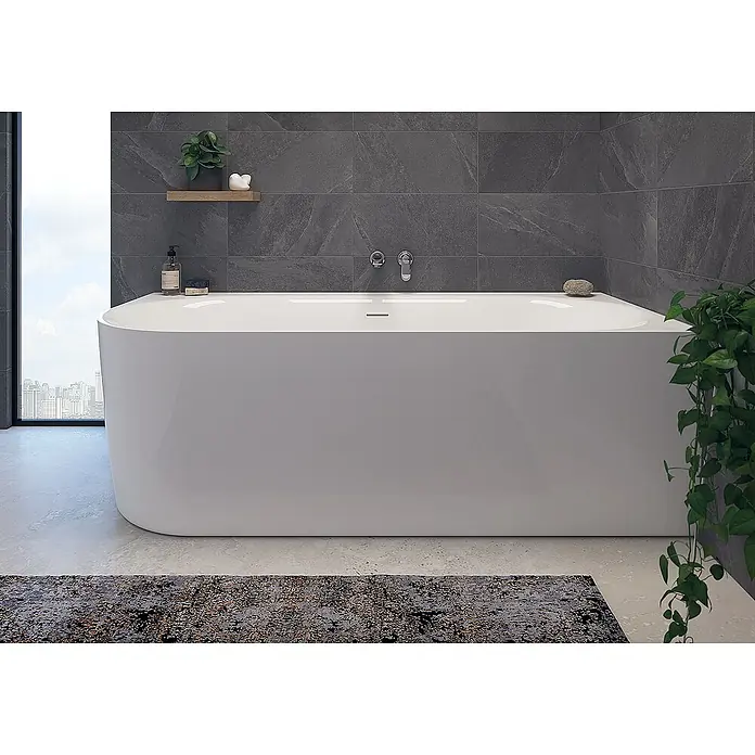 Calmwaters Freistehende Badewanne Seamless Comfort - Sanitäracryl, Weiß - Elegante freistehende Badewanne in einem modernen Badezimmer mit grauen Fliesen, minimalistischer Dekoration und einem Teppich.