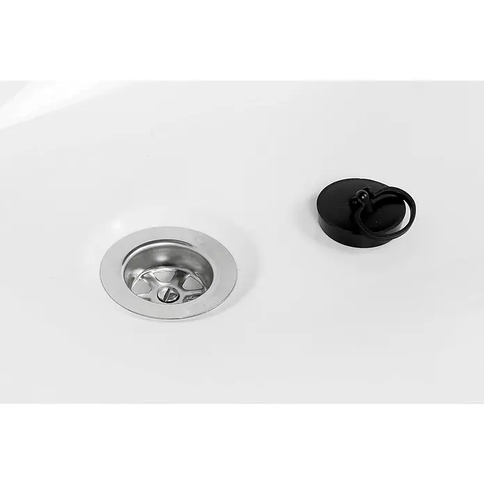 Calmwaters Eckbadewanne Curved Wellness - L x B: 150 x 150 cm, Sanitäracryl, Weiß - Waschbeckenablauf mit Stopfen. Der glänzende Chromablauf und der schwarze Stopfen liegen auf einer strahlend weißen Oberfläche.