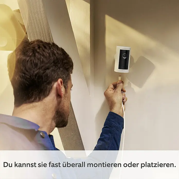 Ring Außenkamera Plus (Plug) - 2.048 x 1.536 Pixel (2K-HD), Weiß - Mann schliesst eine Ring Sicherheitskamera an. Sie können sie fast überall montieren oder platzieren.