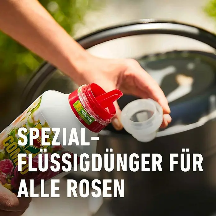Compo Rosendünger - 1 l - Flüssigdünger für Rosen: Eine Hand giesst Spezial-Flüssigdünger für alle Rosen in einen dunklen Eimer im Garten.