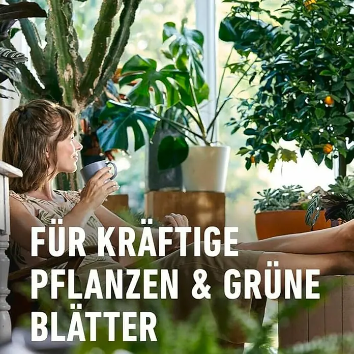 Compo Universaldünger - 1 l - Frau entspannt mit Tasse, umgeben von üppigen Pflanzen. Ideal für kräftige Pflanzen und grüne Blätter mit dem richtigen Dünger.