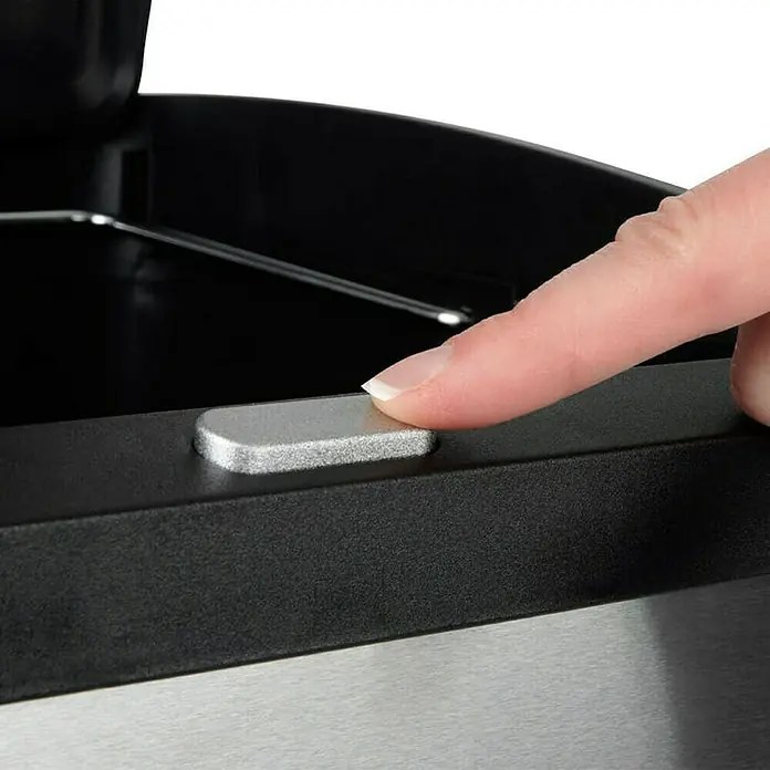 Floordirekt Standard Mülleimer Dylan 2 Kammern 34 L - 34 l, Edelstahl, Silber - Nahaufnahme einer Person, die einen silbernen Knopf an einem Mülleimer drückt, um den Deckel zu öffnen.