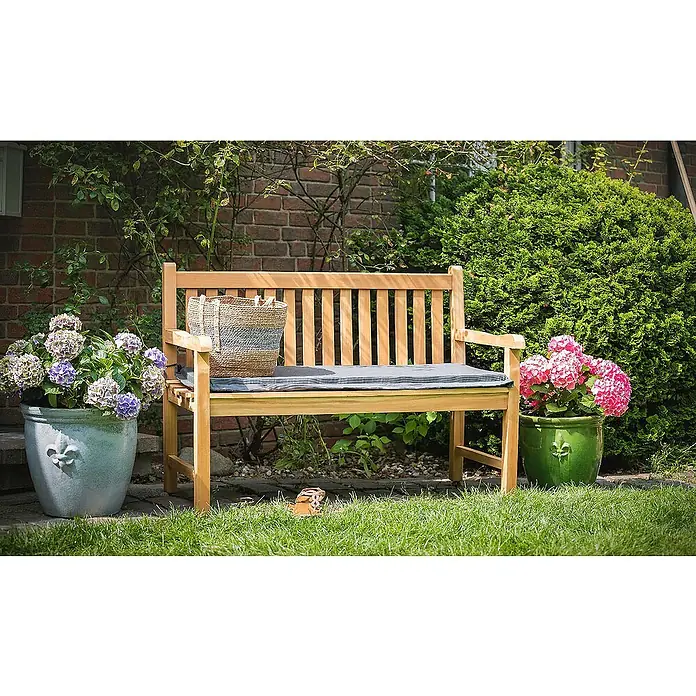 Kai Wiechmann Bankauflage - Gartenbank, Holzbank, Bank, L x B x H: 47 x 110 x 5 cm, Polyacryl, Dunkelgrün - Einladende Gartenszene mit einer Holzbank, einem Korb und blühenden Hortensien in Töpfen, die eine ruhige Atmosphäre schaffen.